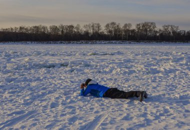 Heilongjiang Eyaleti, Kuzey Çin'de kar nehri üzerinde yatan bir adam.