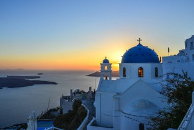 Santorini Adası'nda gün batımında Antik Yunan Ortodoks kilisesi. Santorini dünyanın en popüler adalarından biridir.