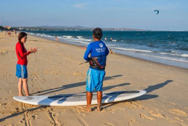 Phan Thiet, Vietnam - 15 Mayıs 2018. Yaz gününde kum plajda sörf okulu öğrencileri eğitim.