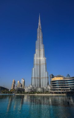 Dubai, Birleşik Arap Emirlikleri - 11 Aralık 2018. Güneşli bir günde Burj Park'tan Dubai çeşmesi üzerinde Burç Khalifa gökdelen görünümü.