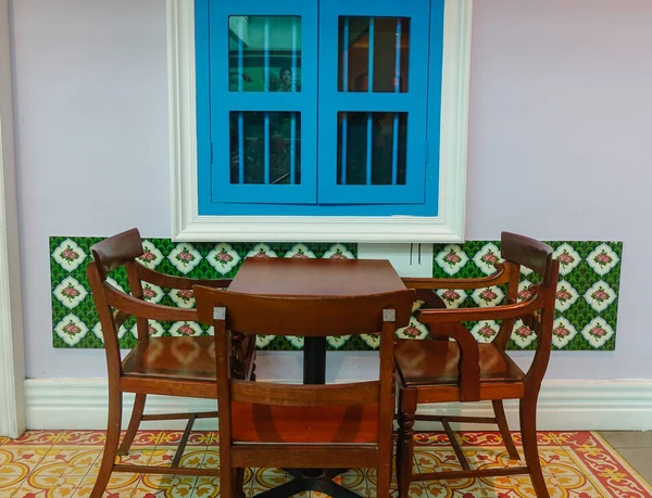 Wooden table and chairs Chinese style near window in old house.