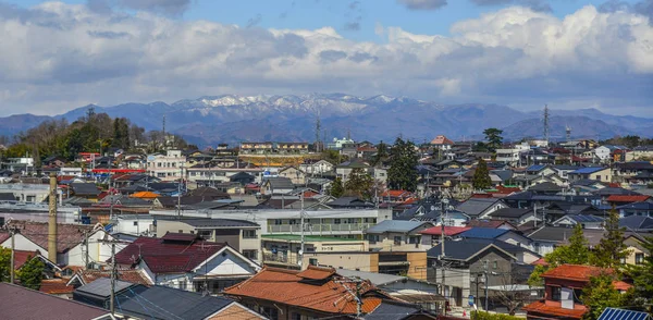 晴れた日の雪山と都市景観 — ストック写真