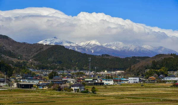 Paisaje urbano con montaña de nieve en día soleado —  Fotos de Stock