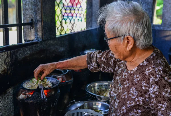 Geleneksel pancake pişirme eski bir kadın — Stok fotoğraf
