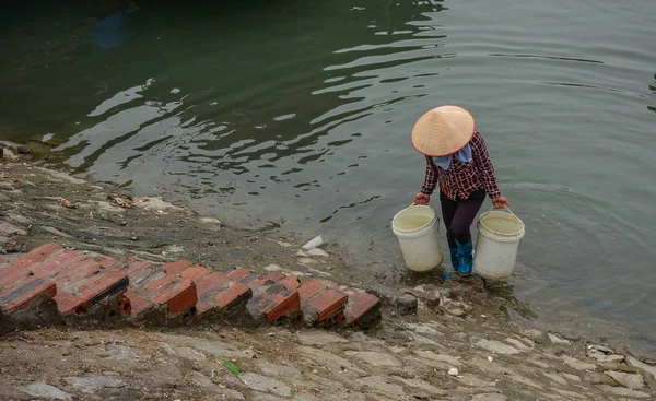 A Vietnamese woman carrying water