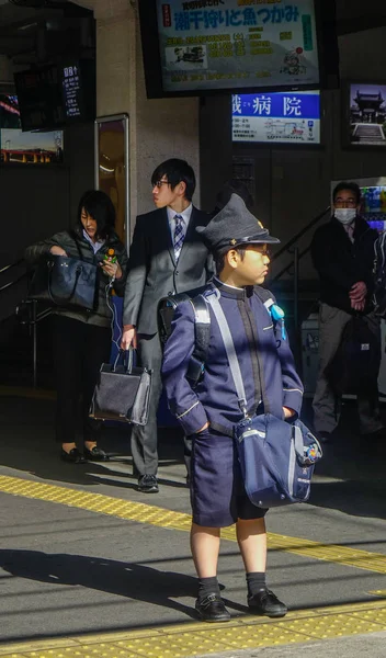 Küçük bir Japon öğrenci treni bekliyor.