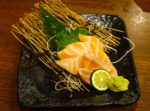 Mancarea japoneza somon sashimi in farfurie neagra — Fotografie, imagine de stoc