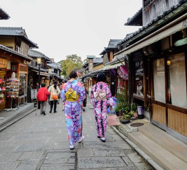 Kadınlar sokakta Japon kimonosu giyer. 