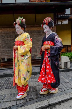 Kadınlar sokakta Japon kimonosu giyer. 