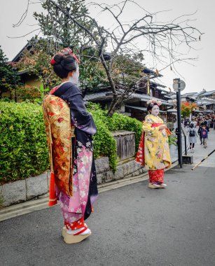 Kadınlar sokakta Japon kimonosu giyer. 