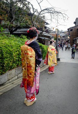 Kadınlar sokakta Japon kimonosu giyer. 