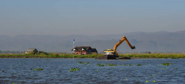 Escavadeira dragas e limpa um lago — Fotografia de Stock
