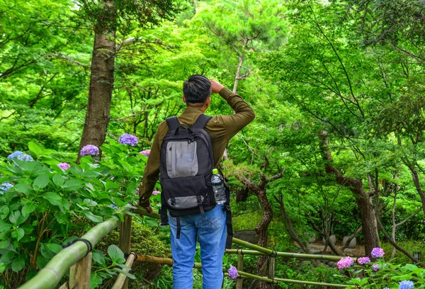 Un giovane uomo che si gode il giardino estivo — Foto Stock