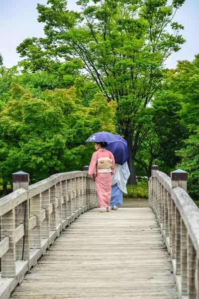 Mujeres en kimono caminando sobre puente de madera — Foto de Stock