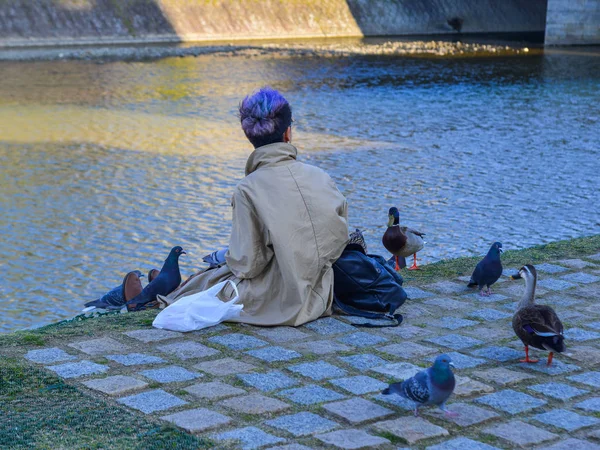 Une jeune femme jouant avec de nombreux oiseaux — Photo