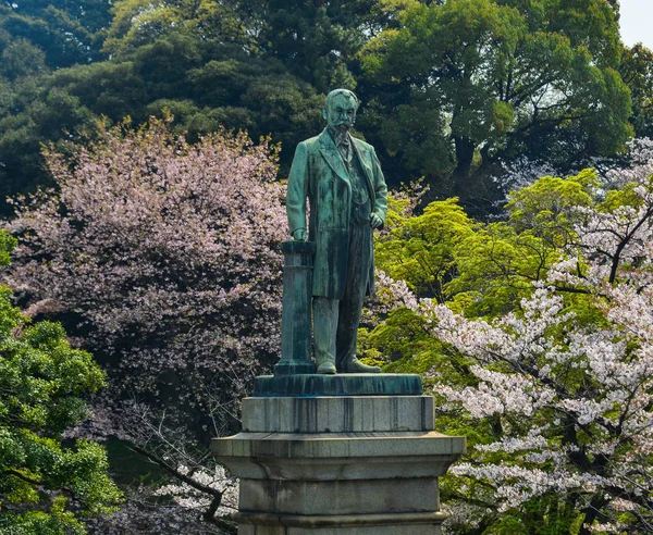 Una estatua de héroe con flor de cerezo en el parque —  Fotos de Stock