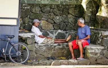 Mauritius'ta oturan ve sohbet eden yaşlı adamlar 