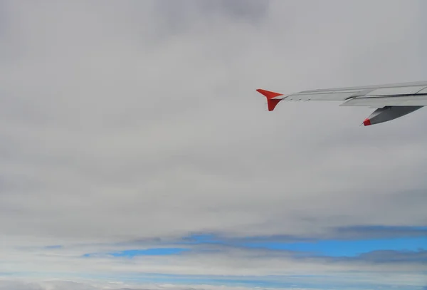 在云层之上飞行的飞机的翼 — 图库照片