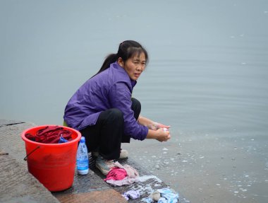 Nehir kıyısında çamaşır yıkayan Çinli kadınlar 