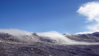 Bulutlar kar dağın üzerinden uçuyor