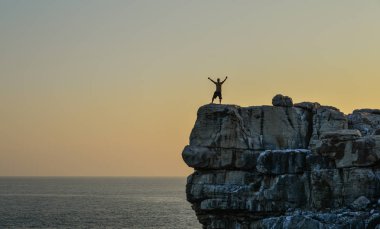 Kayanın üzerinde duran gezgin 