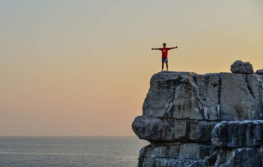 Kayanın üzerinde duran gezgin 