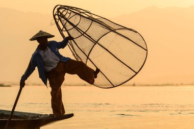 Gün doğumunda Inle Gölü'nde balık yakalamak 