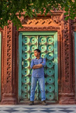 Ahşap kapıda duran genç bir adam. 