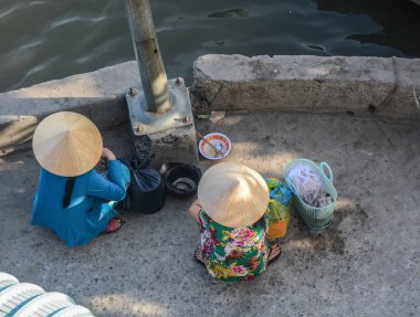 Saygon (Ho Chi Minh şehir), Vietnam sokakta oturan kadın satıcıları. Saygon en büyük şehrive Vietnam Cumhuriyeti eski başkenti.