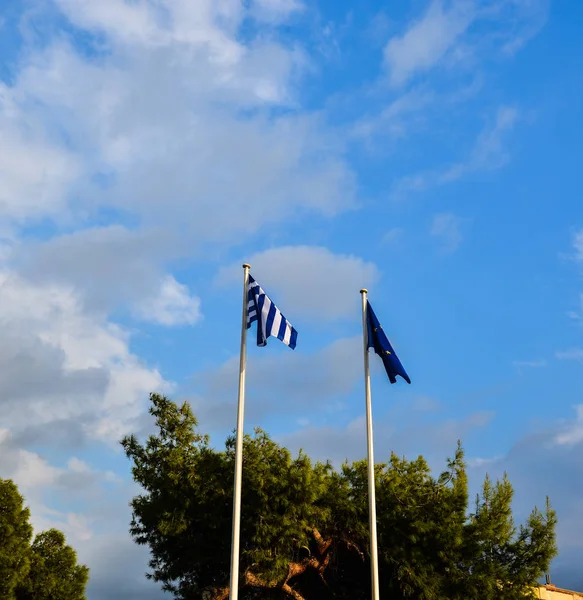 希腊国旗和蓝色欧盟旗帜在蓝天下 — 图库照片