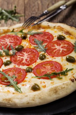 Pizza Vejetaryen taş siyah plaka üzerinde deneyin ile taze domates