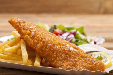 Kızarmış balık ve cips bir kağıt tepsisi üzerinde