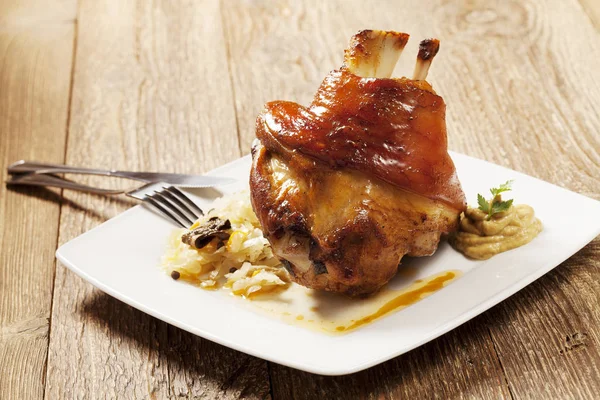 Geroosterd varkensvlees knokkel geserveerd met gekookte kool, brood, horseradis — Stockfoto