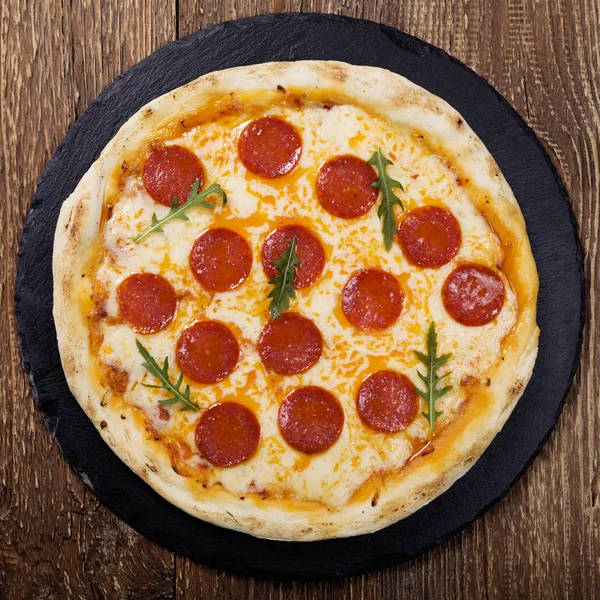 Pizza peperoni på sten svart försök med ruccola och mozzarella che — Stockfoto