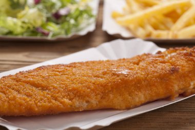 Kızarmış balık ve cips bir kağıt tepsisi üzerinde