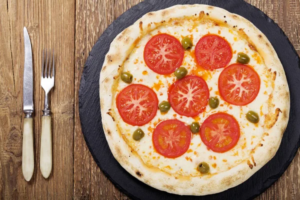 Pizza vegetarisk på plattan på sten svart försök med färska tomater — Stockfoto