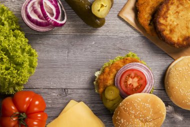 Ev tavuk burger peynir, marul, domates ve soğan ile ahşap tahta üzerinde yapılan