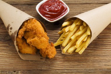 Nuggets ve bir dalış bir ahşap tahta üzerinde bir kağıt torba servis fişleri