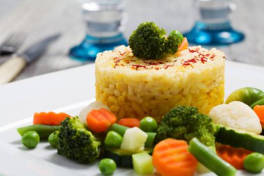Sebzeli risotto kısmı. Beyaz tabakta.