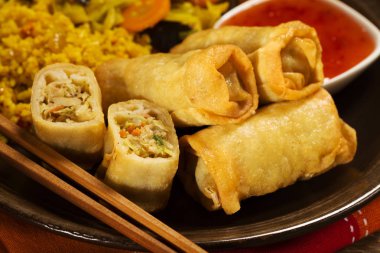 Bölümü spring rolls sebze ve sos ile bir tabak pirinç pişmiş.