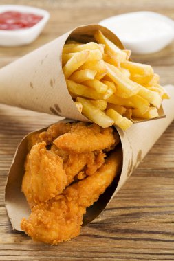 Nuggets ve bir dalış bir ahşap tahta üzerinde bir kağıt torba servis fişleri