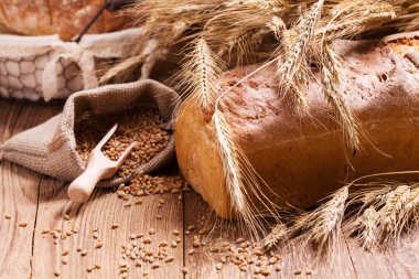 Taze ekmek, tahıl ve tahıl ahşap tahta üzerinde kompozisyon.