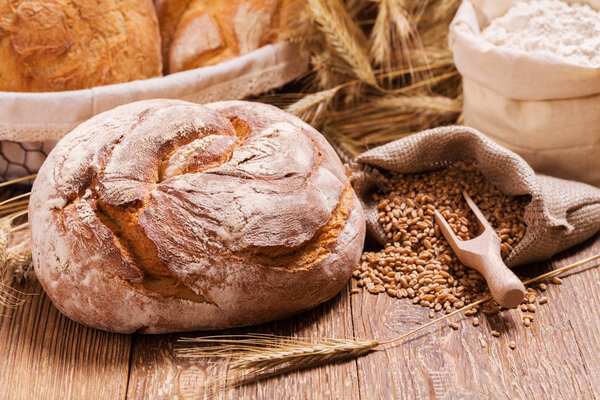 Состав свежего хлеба, круп и зерна на деревянной доске
.