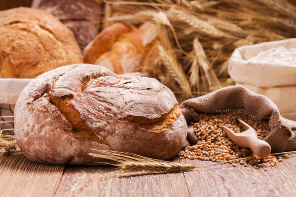 Состав свежего хлеба, круп и зерна на деревянной доске
.