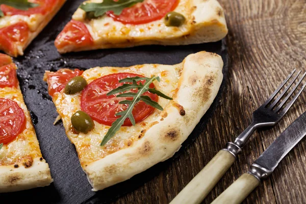 比萨素食者在板材在石头黑尝试用新鲜的蕃茄和橄榄 — 图库照片