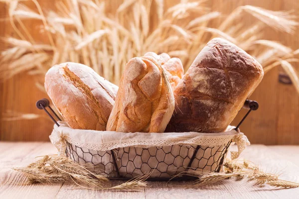 Composition of fresh bread, cereals and grains on wooden board.