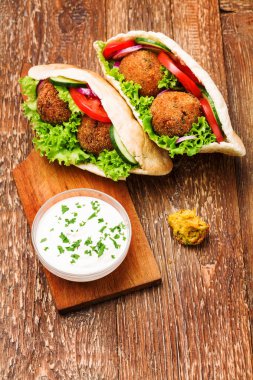 Falafel ve taze sebzeler ahşap masada pide
