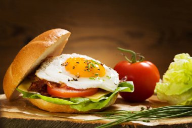 Kızarmış yumurta, pastırma, peynir ve sebzeli sandviç..