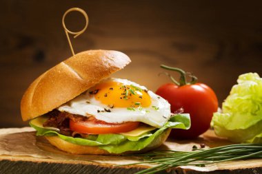 Kızarmış yumurta, pastırma, peynir ve sebzeli sandviç..