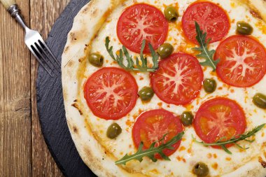 Pizza Vejetaryen taş siyah plaka üzerinde deneyin ile taze domates